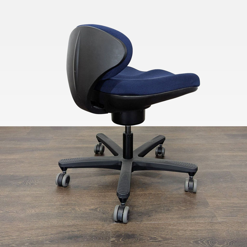 3. Rear view of a CoreChair Tango office chair highlighting curved back support, dark blue upholstery, and stable wheeled base.