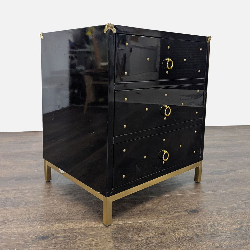 3. Angled side view of black Chic Home dresser with gold ring pulls, gold studs, and modern gold metal legs.