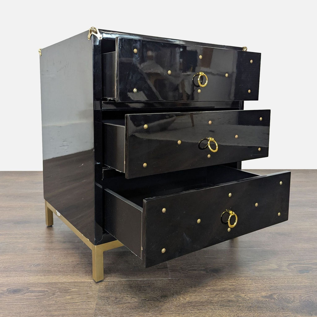2. Three-drawer black dresser by Chic Home shown open, featuring gold ring handles, studs, and gold legs.  