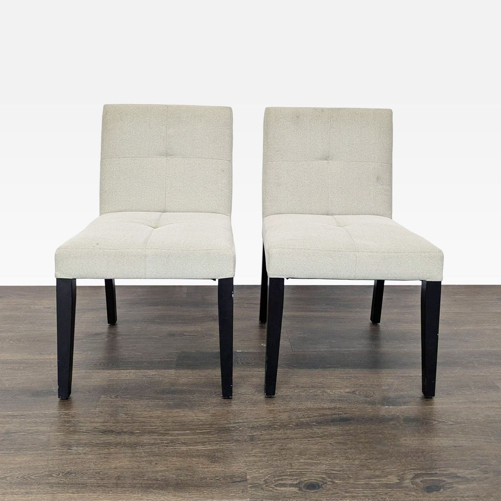 Low-back dining chairs with wooden legs, designed by Crate & Barrel, displayed in a modern setting.