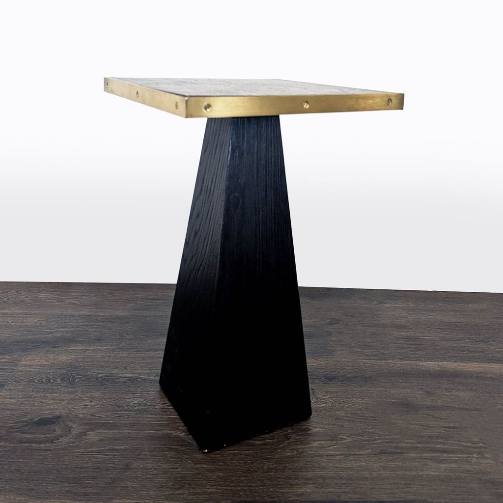 Modern end table with a wood pedestal design and a thin metal border.