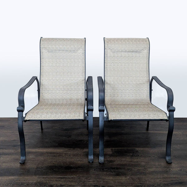 Pair of patio chairs with black metal frames, beige mesh seats, and high backs, suitable for outdoor use.