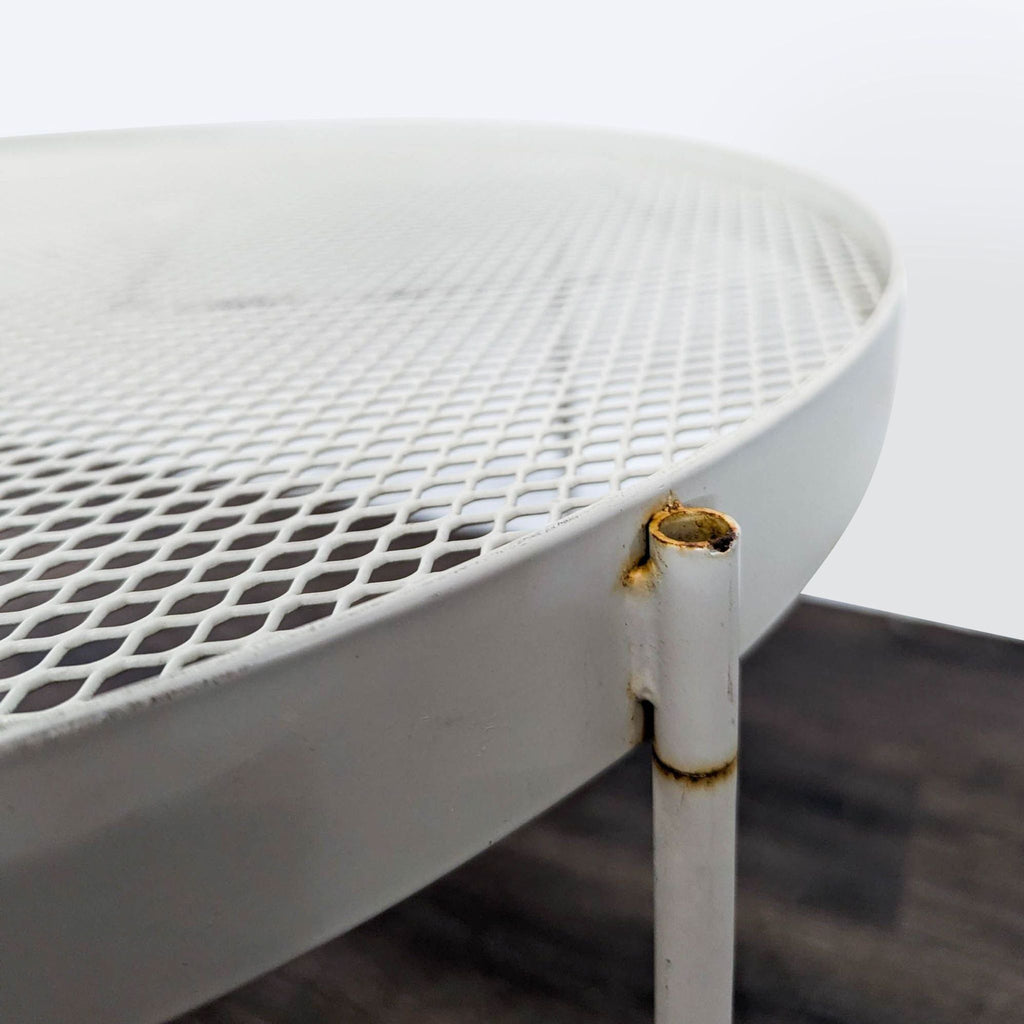 Modern round white metal table by IKEA, mesh top and stable legs, some rust spots but practical for patio or living room.