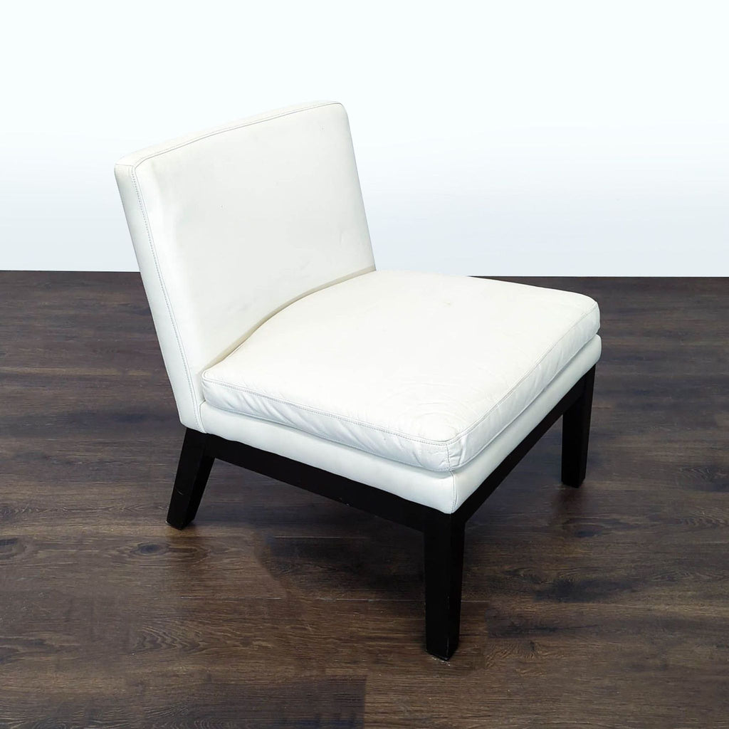 Sleek armless lounge chair featuring a plush white cushion and sturdy black legs, ideal for any lounge space.