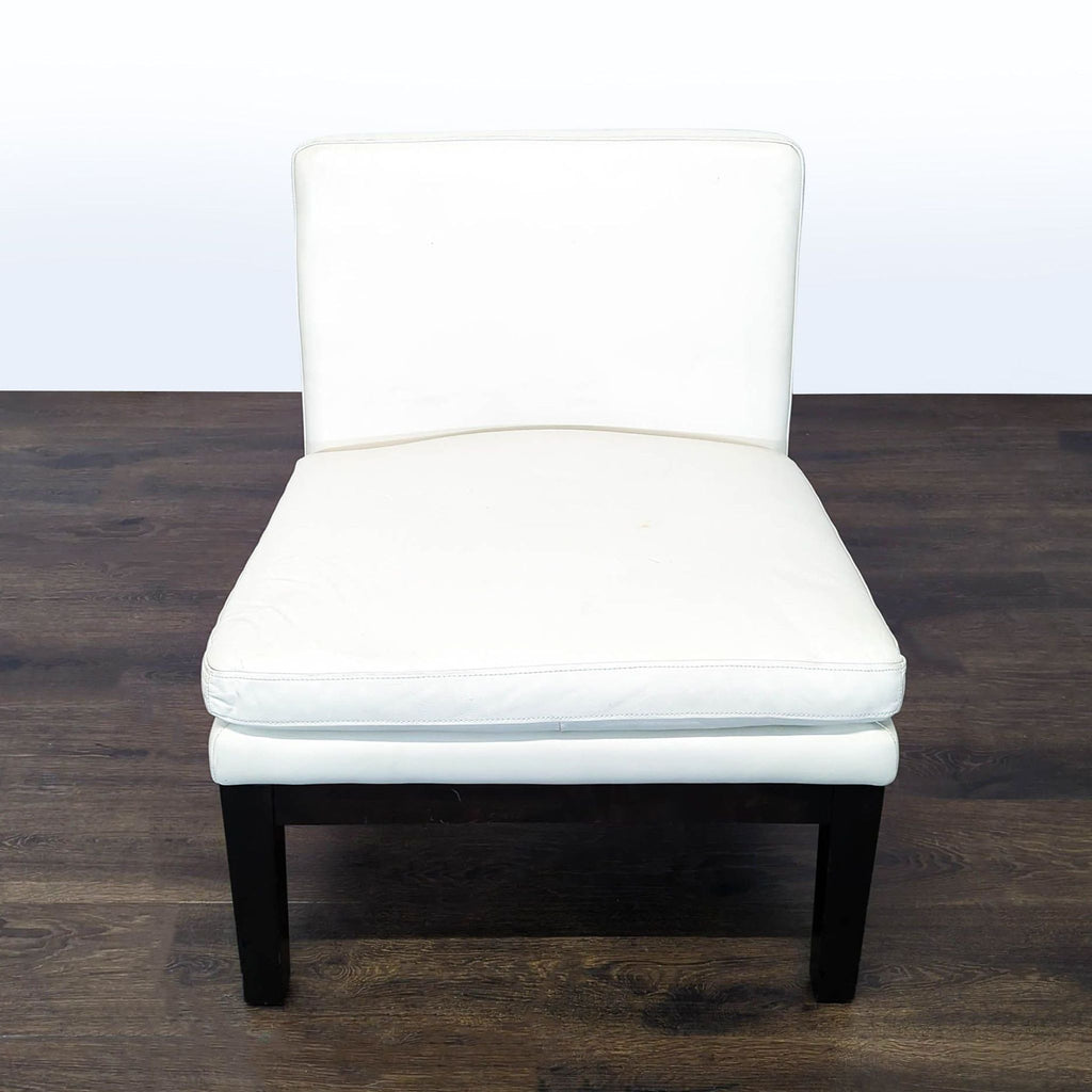 Modern white lounge chair with black wooden legs and no armrests, perfect for contemporary living rooms.