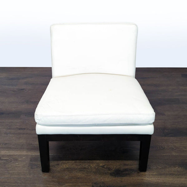 Modern white lounge chair with black wooden legs and no armrests, perfect for contemporary living rooms.