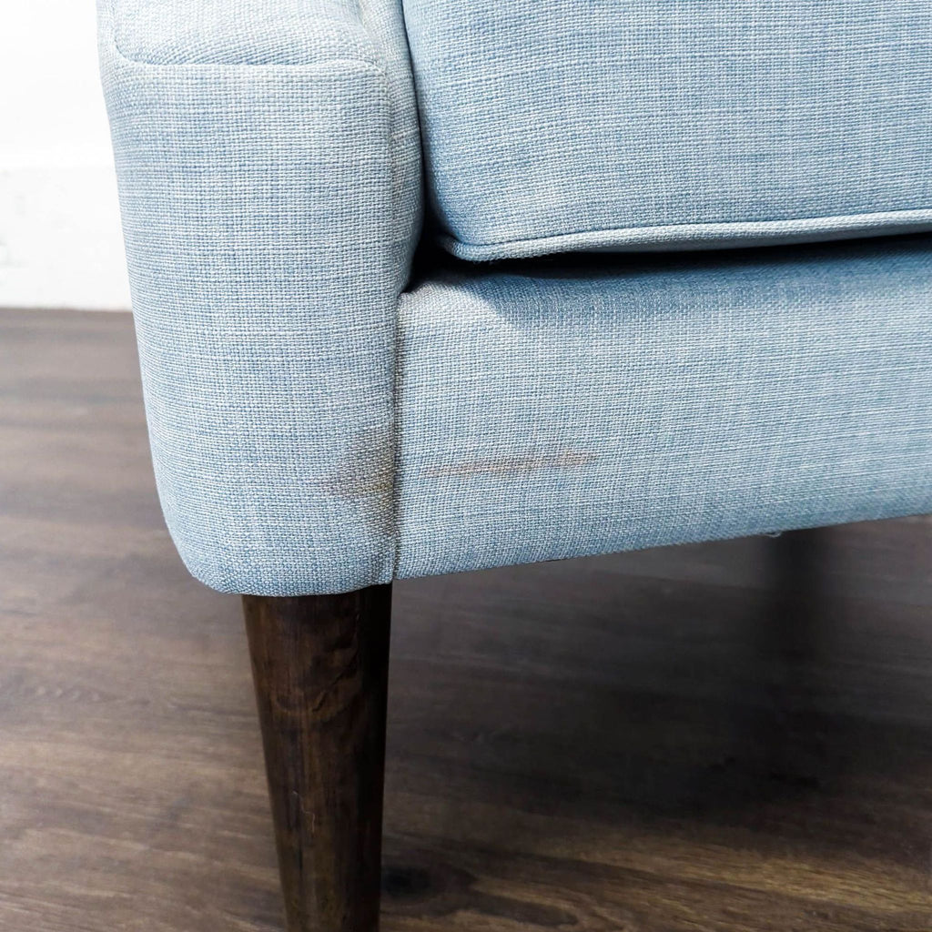 Madison Park lounge chair featuring a plush blue seat, curved arms, tufting, and stylish dark legs.