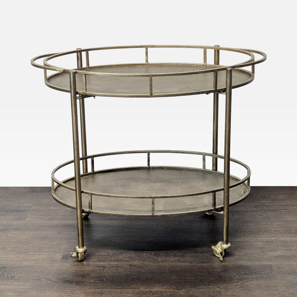 1. Round two-tiered metal serving cart with rails and casters, displayed on a dark wooden floor.