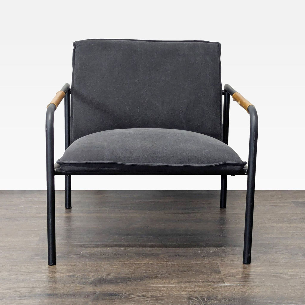 Sauder lounge chair with black cushion, metal frame, and wood armrest accents in a modern style.