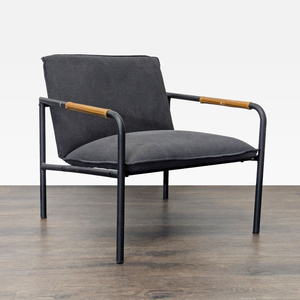 Black cushioned Sauder lounge chair featuring wooden armrest details and a sturdy black metal frame.