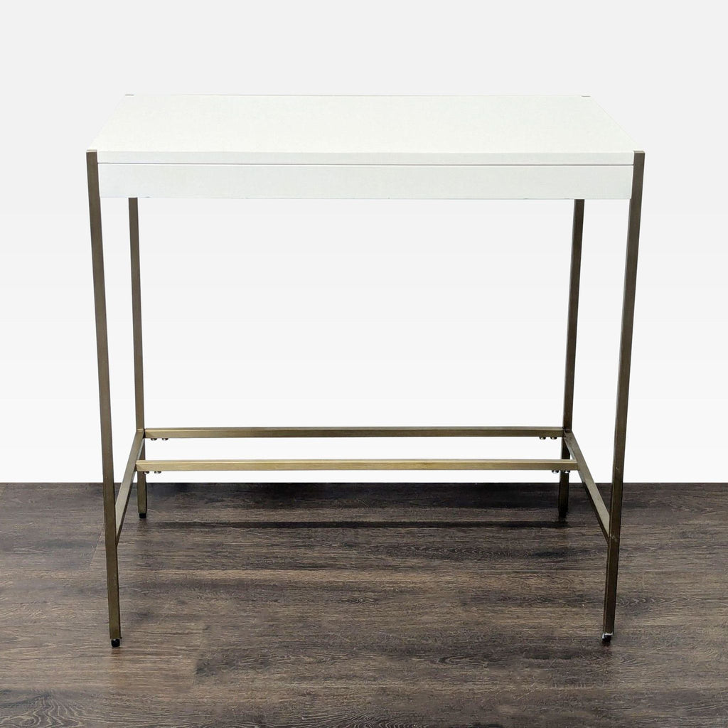 West Elm desk with a white top and brass frame, compact and modern, ideal for small spaces.