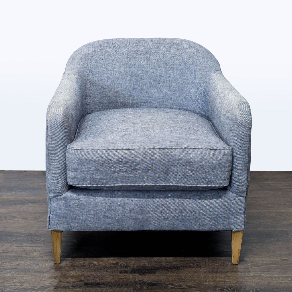 Blue lounge chair with curved backrest and wooden legs, from Restoration Hardware, in a modern style.