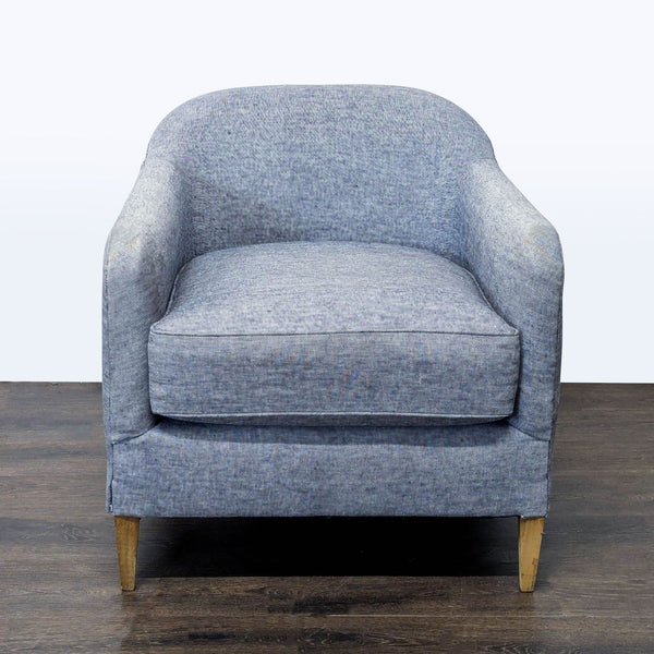 Blue lounge chair with curved backrest and wooden legs, from Restoration Hardware, in a modern style.