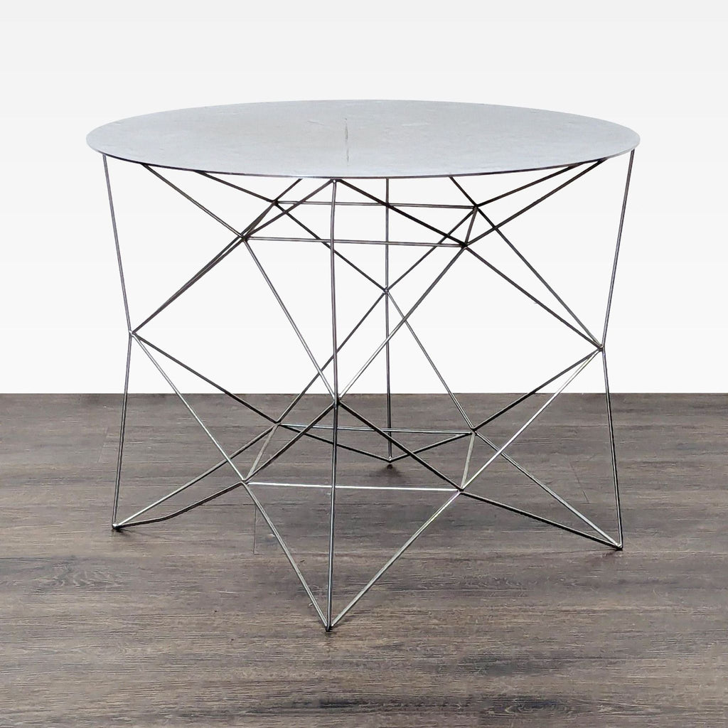 3. Contemporary round end table by West Elm with a minimalist marble surface and open wireframe metal legs.