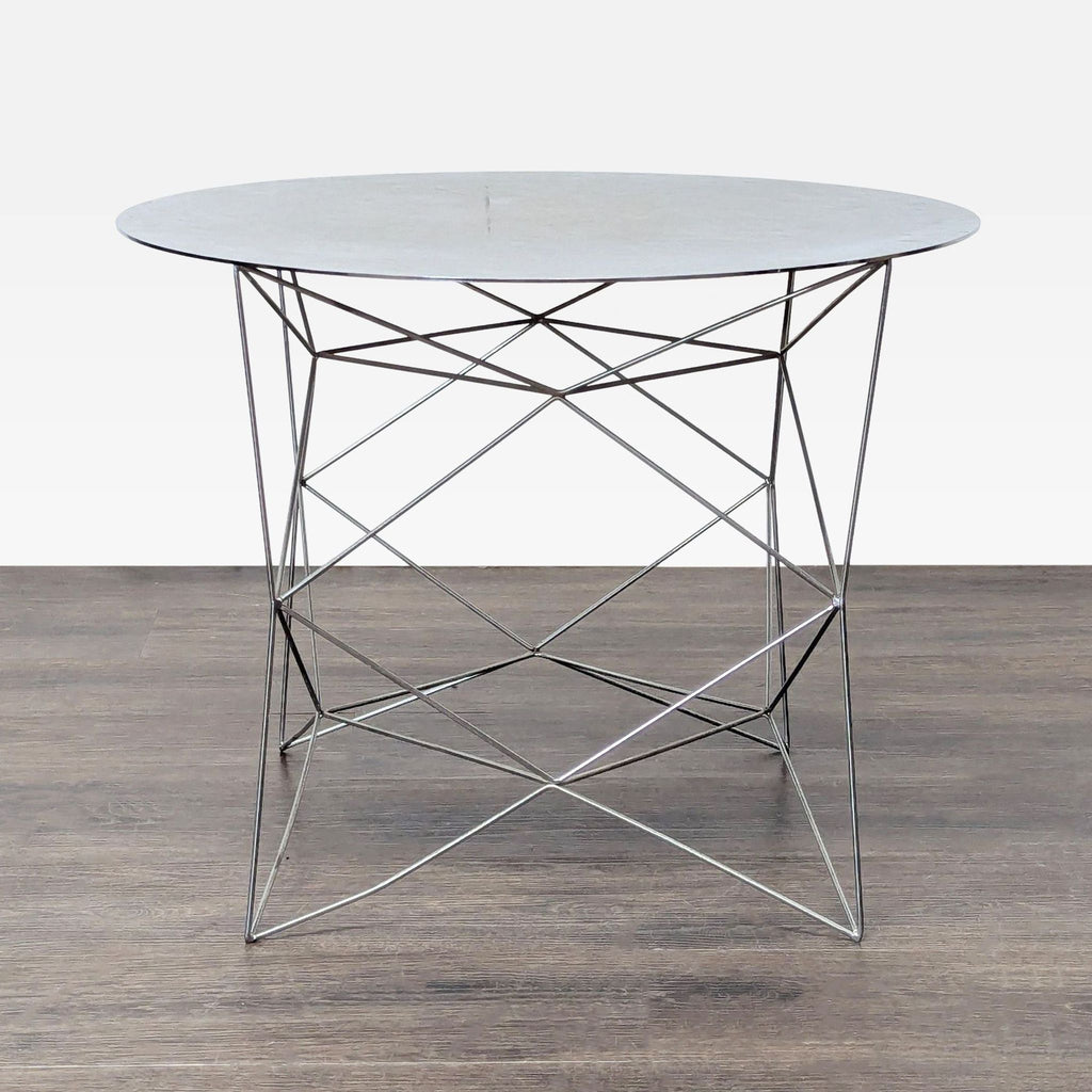 2. West Elm end table featuring a sleek round white top and distinctive crisscrossed metal frame.