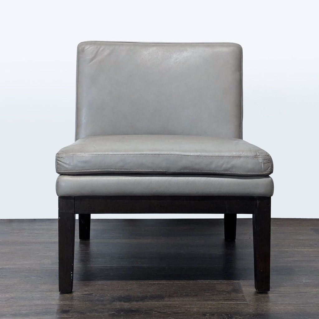 1. West Elm lounge chair with a gray leather seat, armless design, and dark wooden legs, front view.