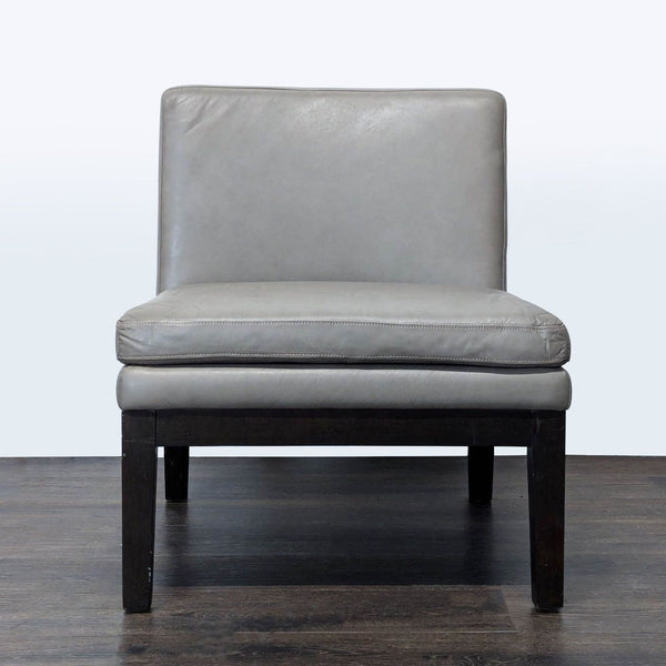 1. West Elm lounge chair with a gray leather seat, armless design, and dark wooden legs, front view.