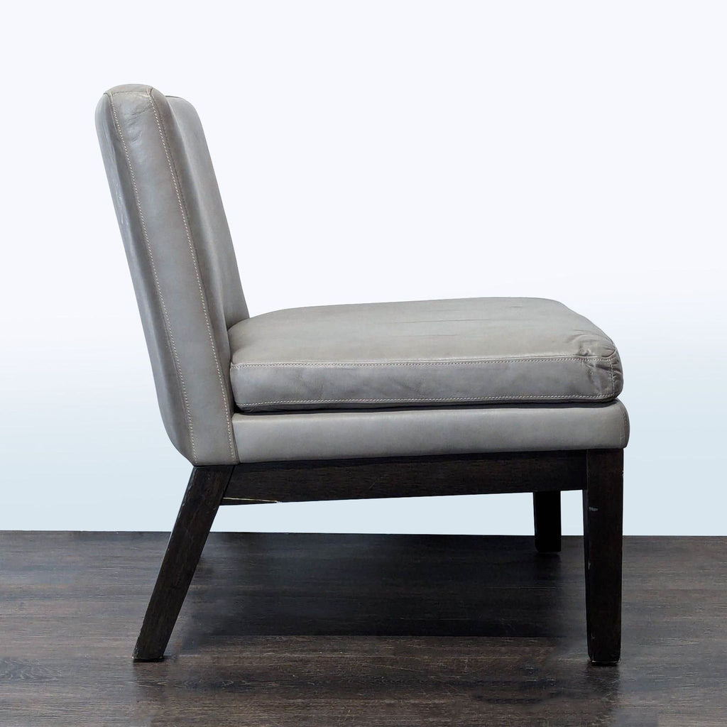 3. Side profile of a West Elm lounge chair in gray leather, showing its sleek, minimalist lounge style.