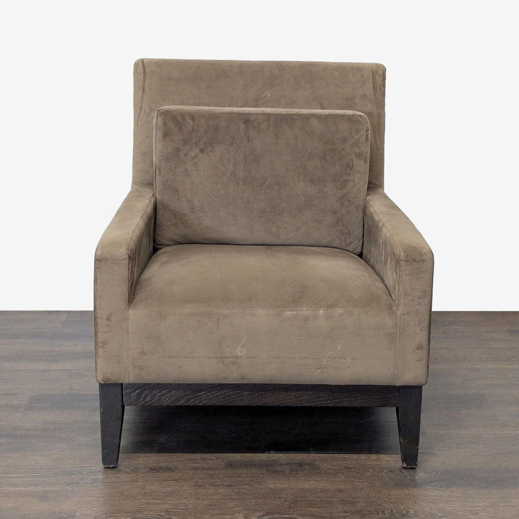 Modern West Elm armchair with brown upholstery, cushioned seat and back, and sturdy wooden legs.