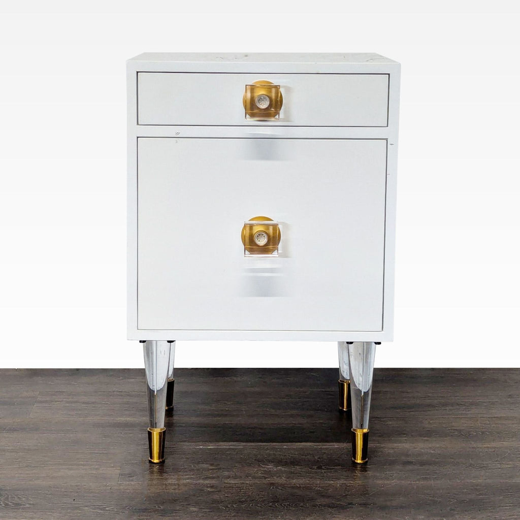 1. White end table with one drawer, one cabinet featuring lucite and brass legs and hardware, shown from the front.