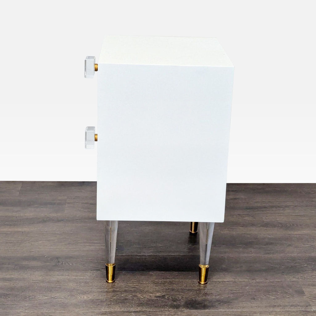 2. Side view of a white end table, highlighting lucite and brass drawer and cabinet hardware and legs.