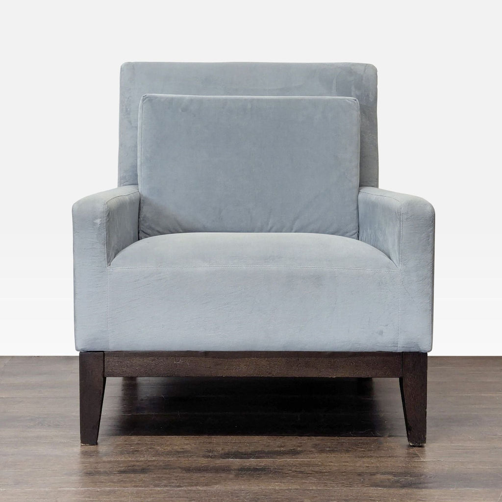 Modern West Elm lounge chair with soft gray fabric, dark wood legs, and a matching back cushion for comfort.  