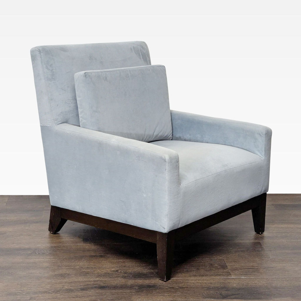 West Elm gray upholstered lounge chair featuring sturdy dark wood legs and a supportive, removable back cushion.  