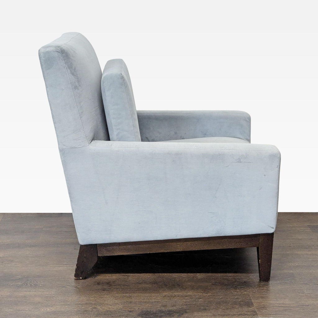 Contemporary lounge chair by West Elm in gray upholstery with cushioned back and durable dark wood legs.