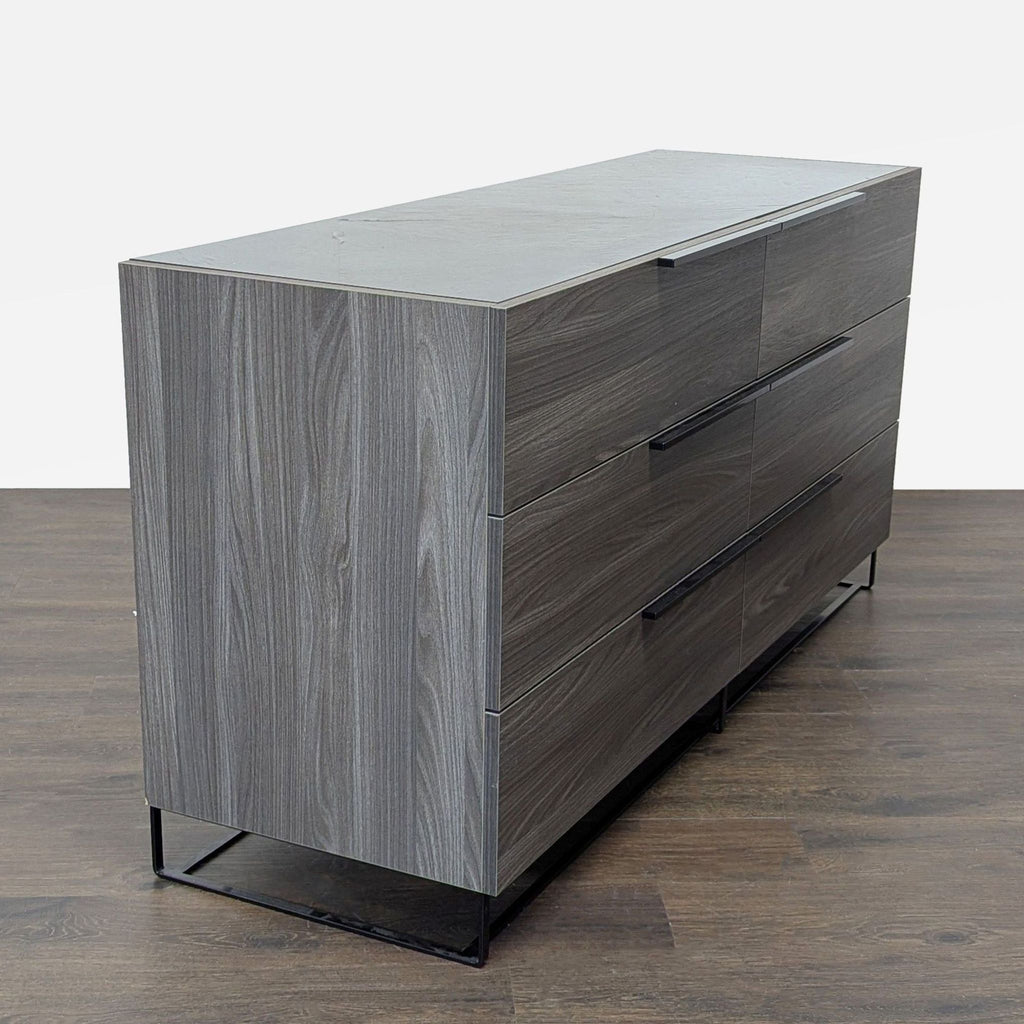 Minimalist Modrest dresser with six drawers in a gray finish and black metal legs, ideal for organized storage.