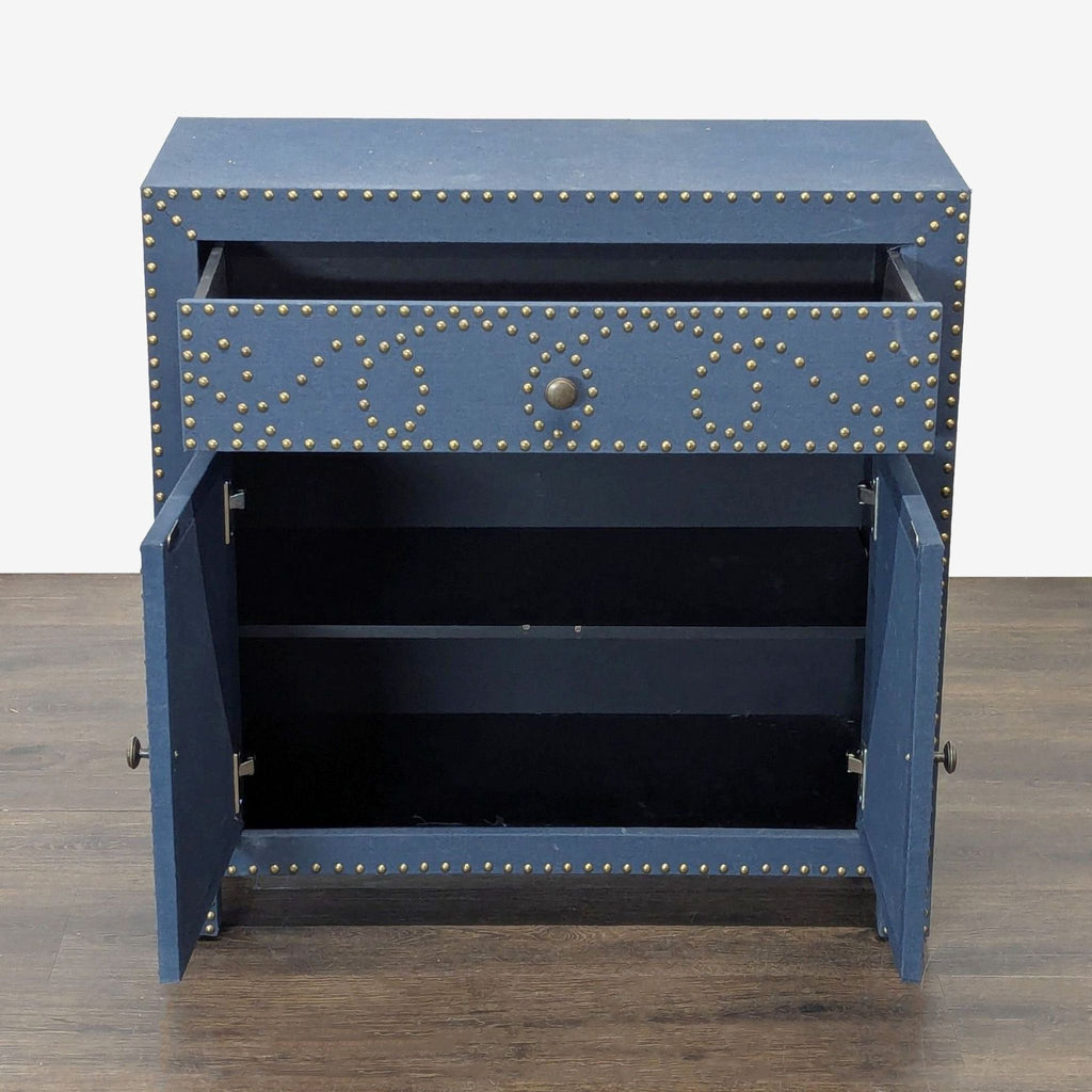 2. Opened Bungalow Rose navy cabinet showing interior shelf and single drawer above double doors with nailhead accents.