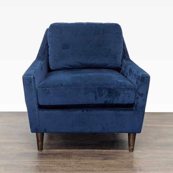 Blue velvet West Elm lounge chair with cushioned seat, angled arms, and modern wooden legs.