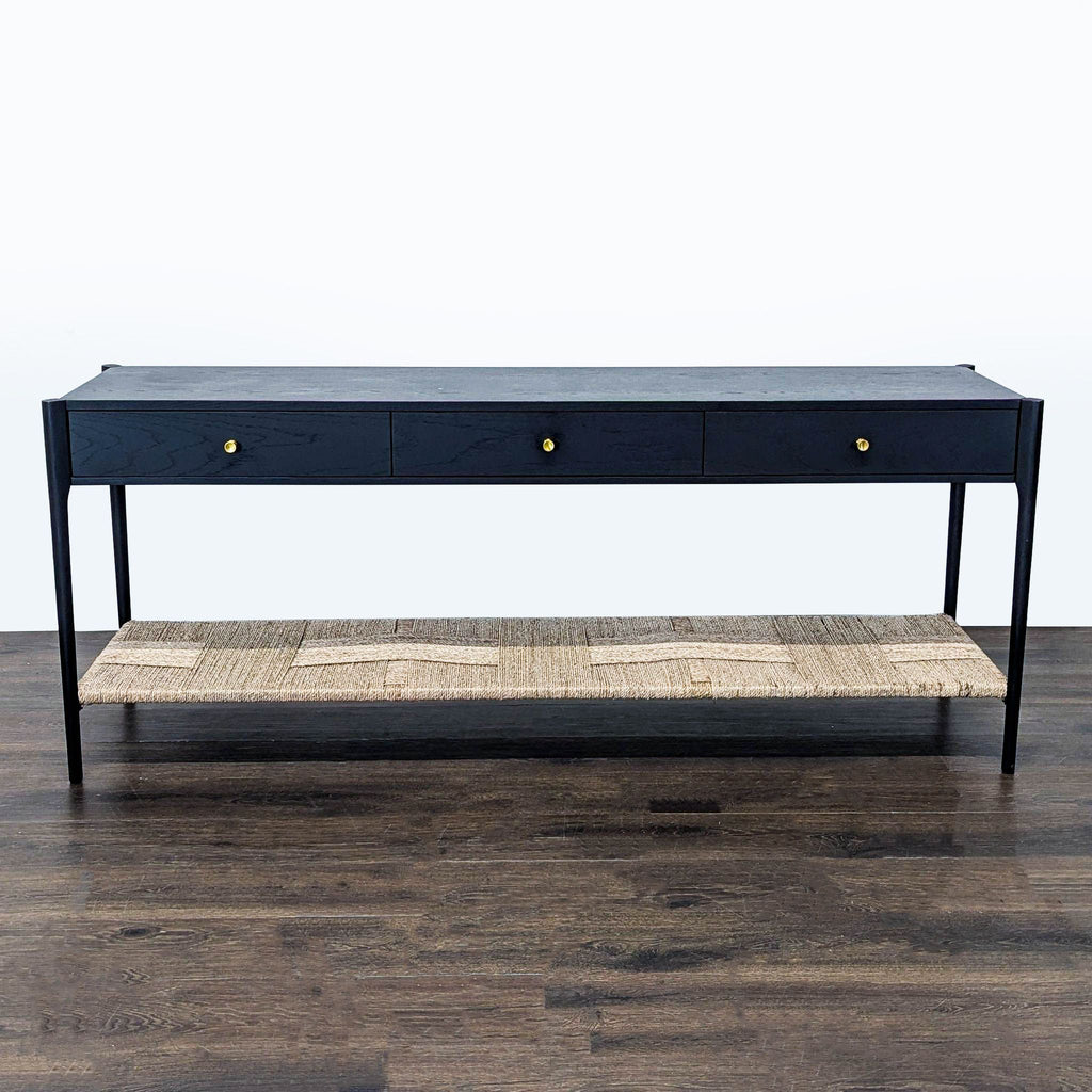 Arhaus side table with three drawers, brass handles, and a woven rope shelf below.