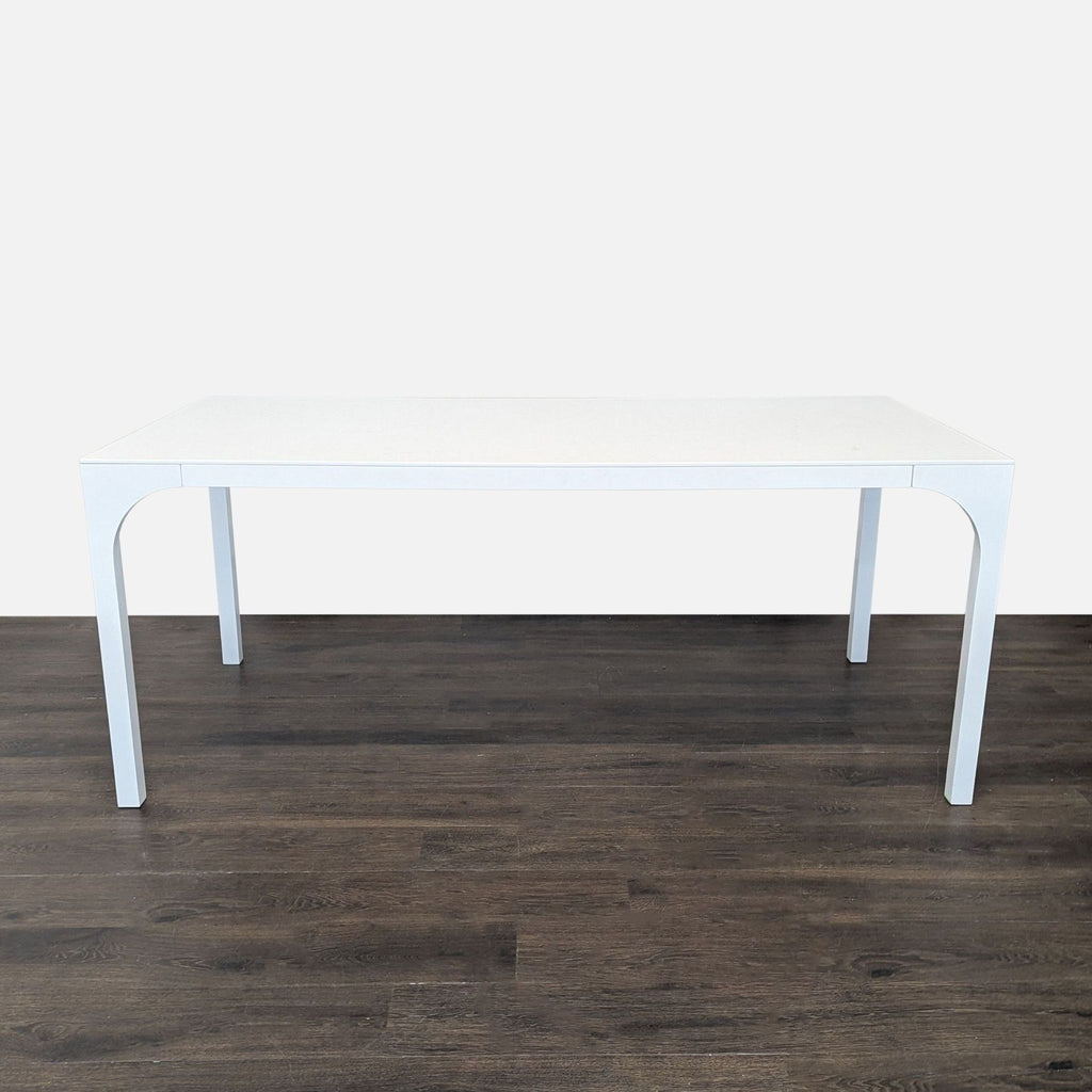 Sleek white lacquered table from CB2, inspired by Roman aqueducts and high-speed train design, with arched curving legs.  