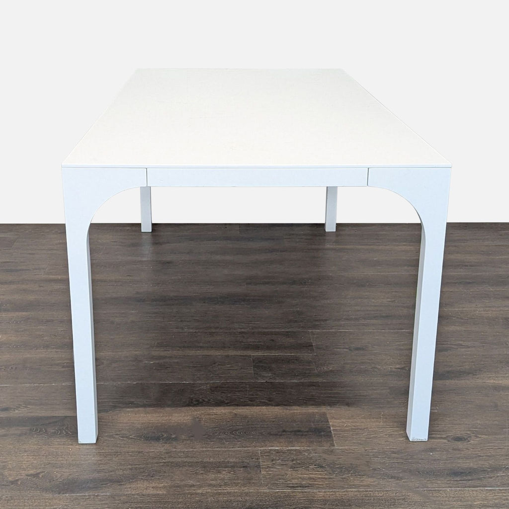 Contemporary CB2 table with a glossy finish and arching legs, blending ancient Roman and high-speed rail architectural motifs.