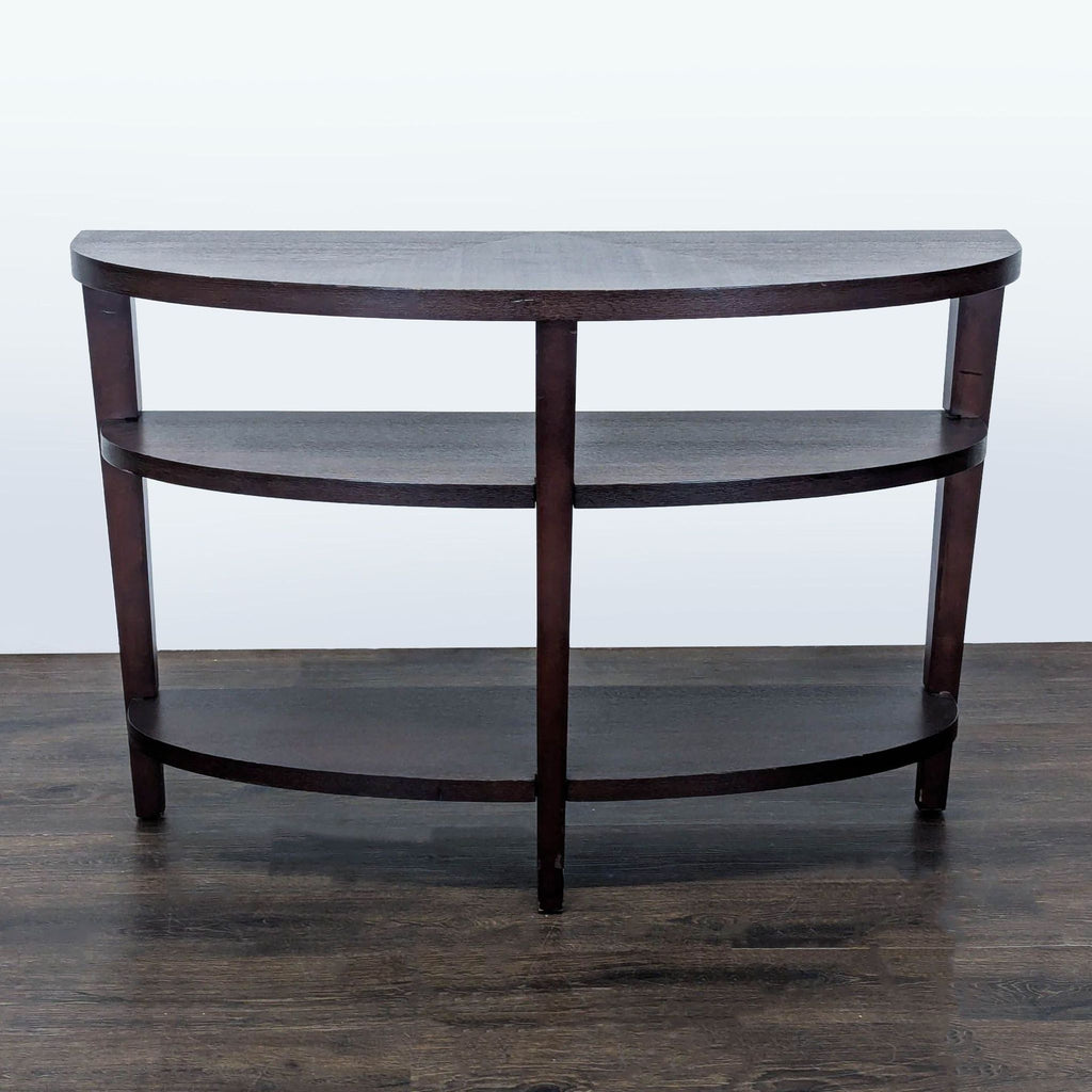 1. Dark wood three-tier half-moon console table with open shelves, shown from the front on a wood floor.  