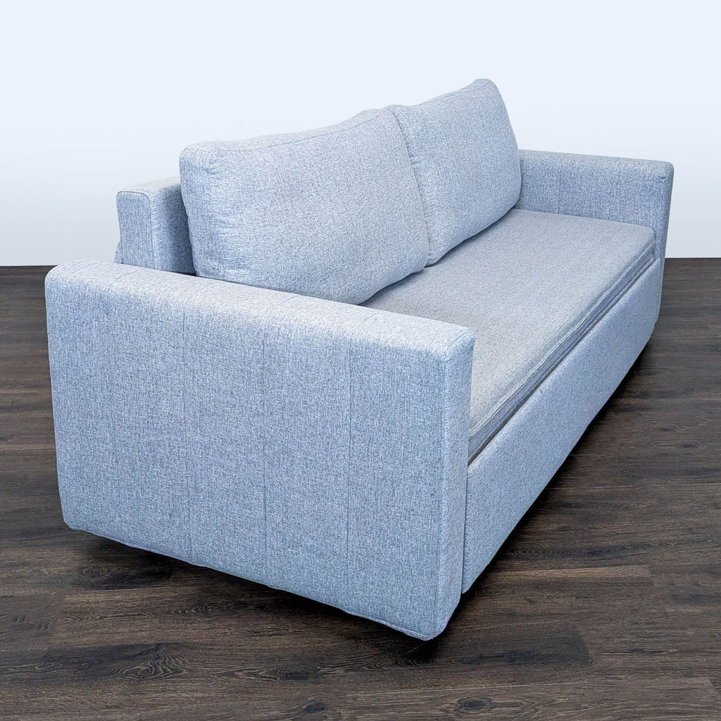 Stylish light gray couch that transforms into a bed, offering practical seating and sleeping solutions for any room.