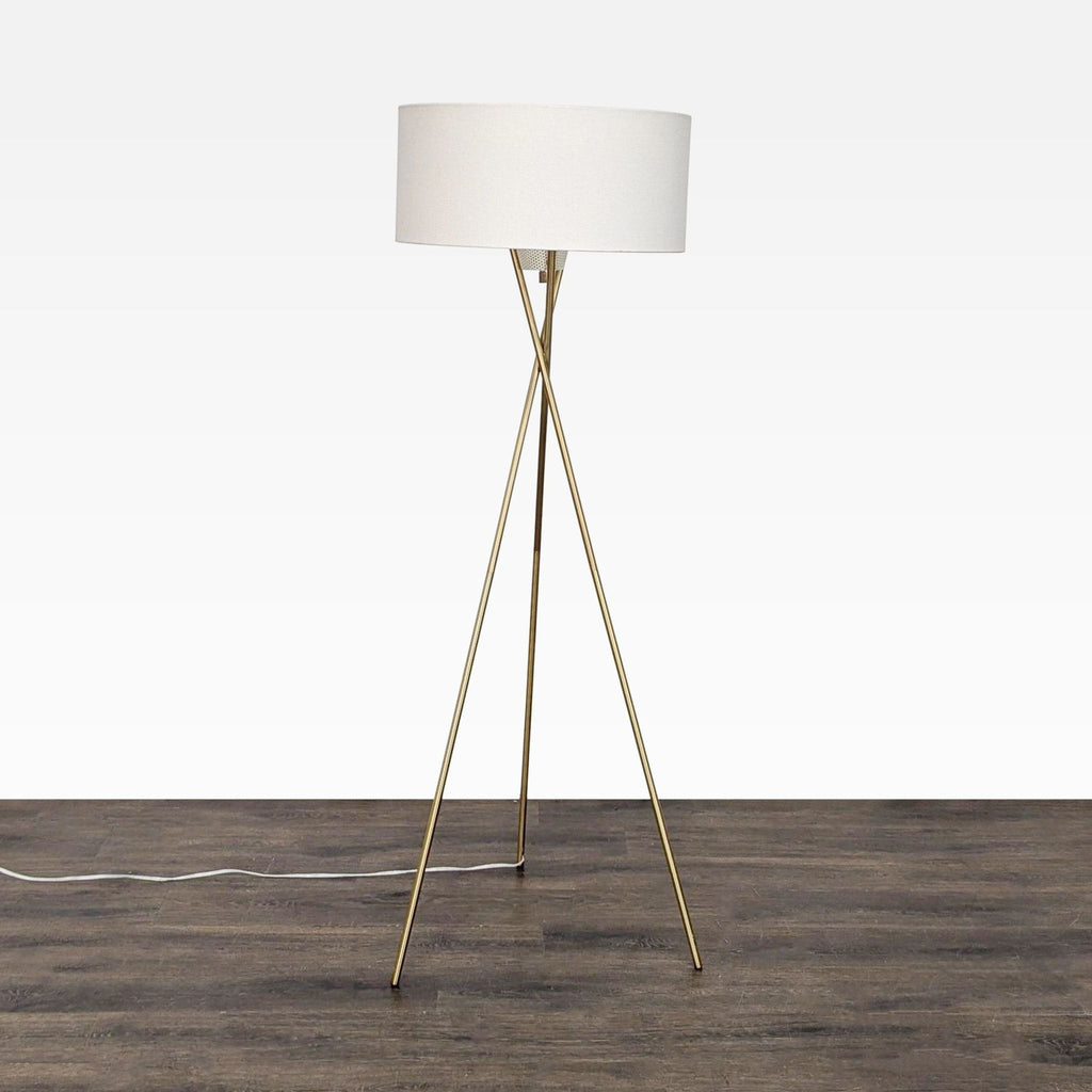 Sleek lighting category lamp with brass base, white drum shade, and warm glow, perfect for stylish interiors.
