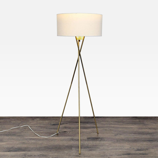 Brass tripod floor lamp with white drum shade and perforated diffuser, ideal for modern living rooms or offices.  