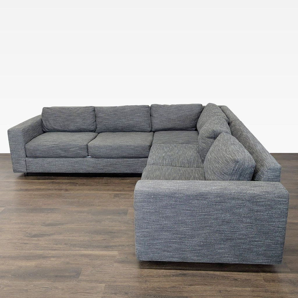 Stylish West Elm sofa in soft gray fabric, offering comfortable and supportive seating in contemporary design.