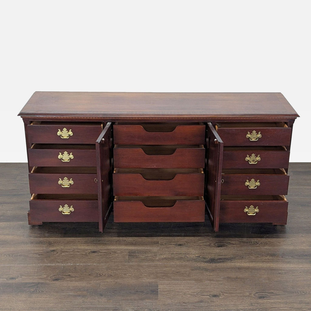 Classic Thomasville wooden dresser featuring multiple drawers, a central cabinet, and elegant brass handles.  