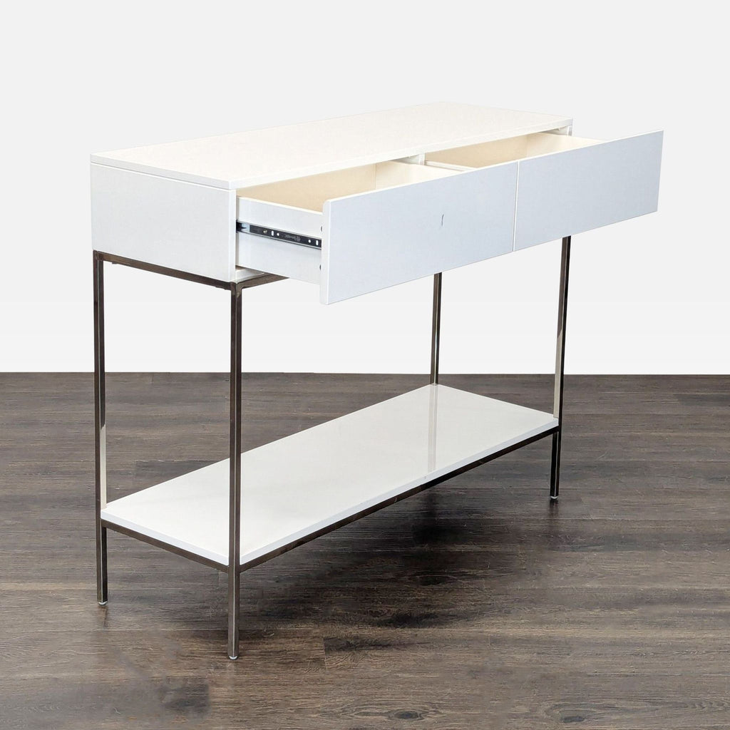 2. Side angle of a West Elm white console table showing two open drawers and a lower shelf, modern design.  
