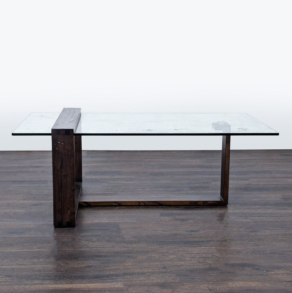 1. Living Spaces coffee table with a clear glass top and solid Mindi wood base in mid-century modern style.