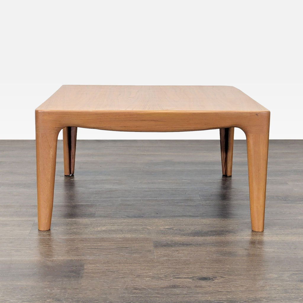 3. Contemporary wooden coffee table with a simple square top and subtly curved sides, shown from the front.