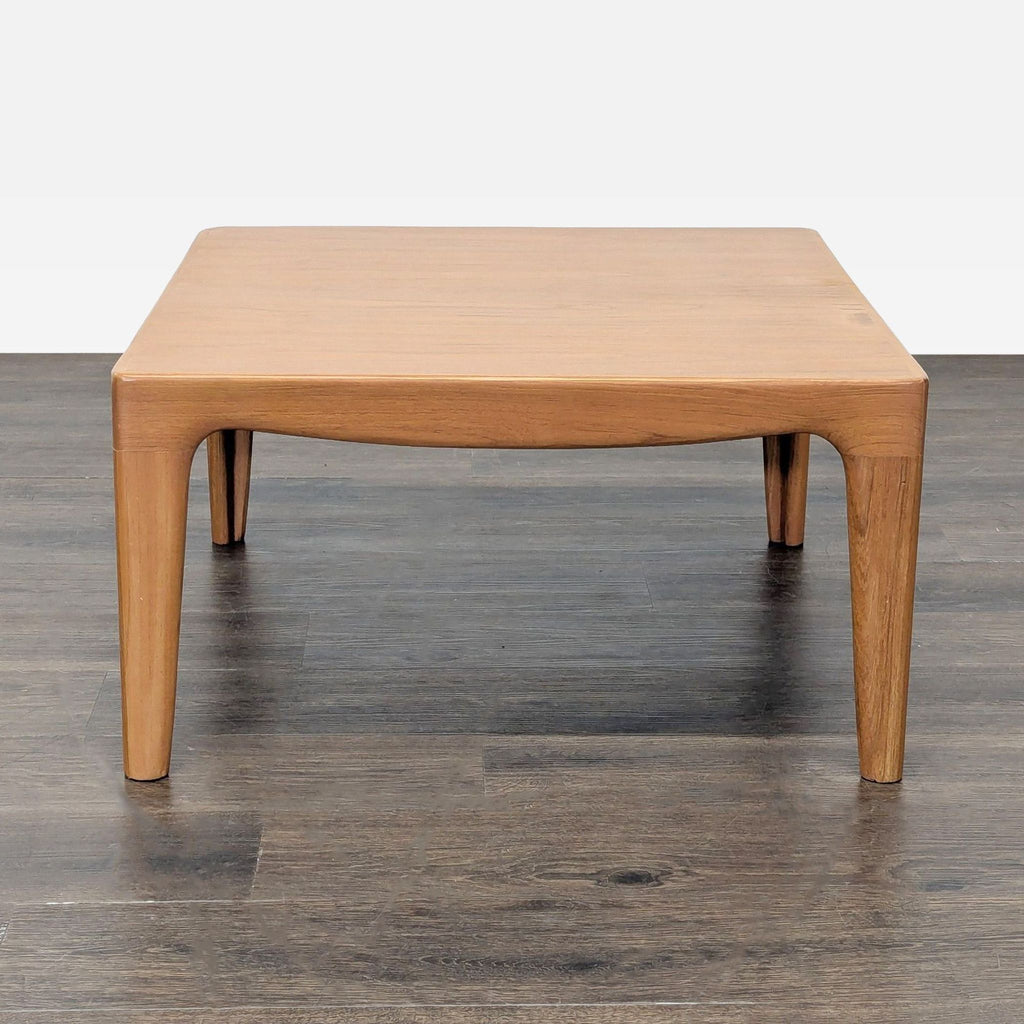 2. Minimalist light wood coffee table featuring smooth curves and four slim legs, photographed head-on.