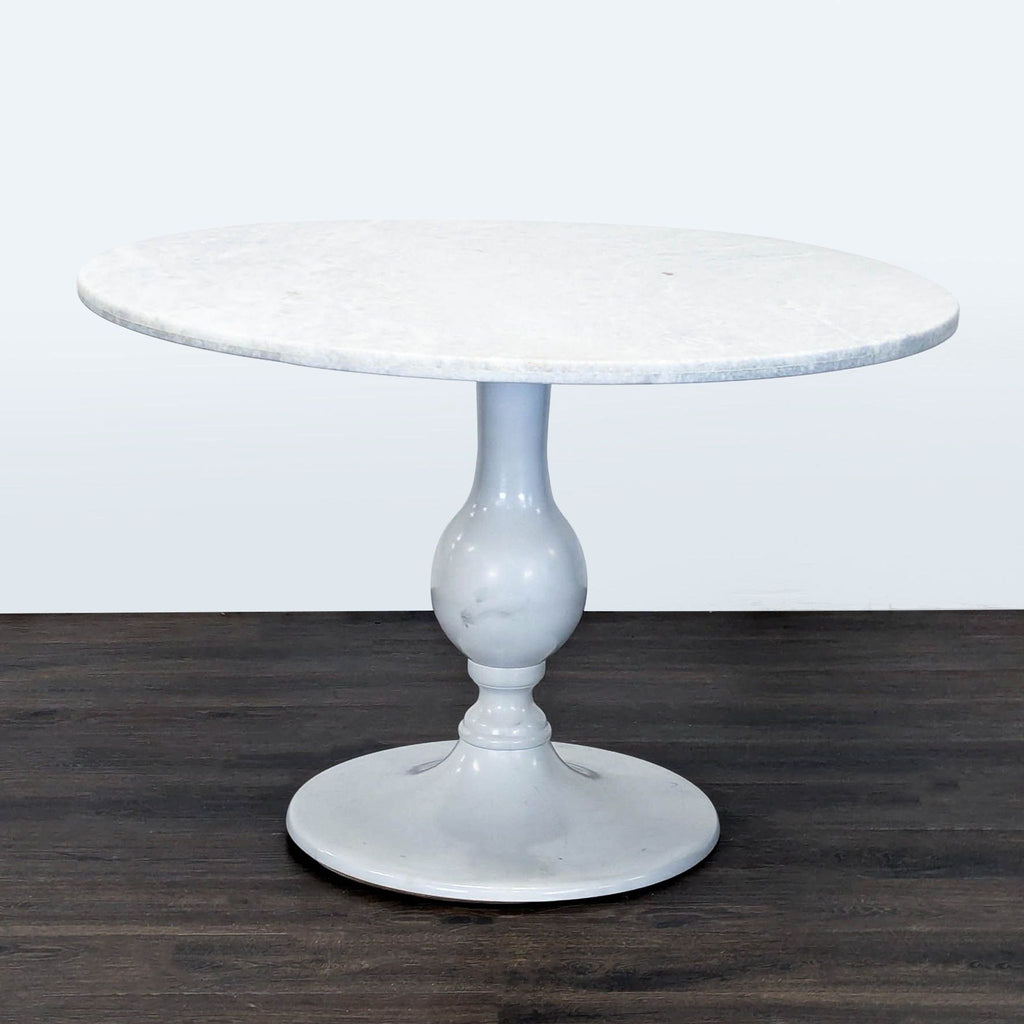 Anthropologie dining table featuring a sturdy metal pedestal base.  