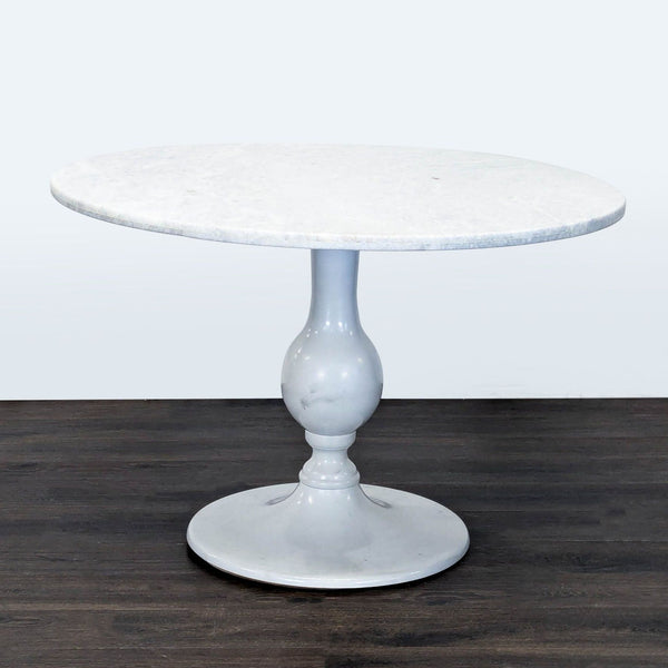 Anthropologie dining table featuring a sturdy metal pedestal base.  