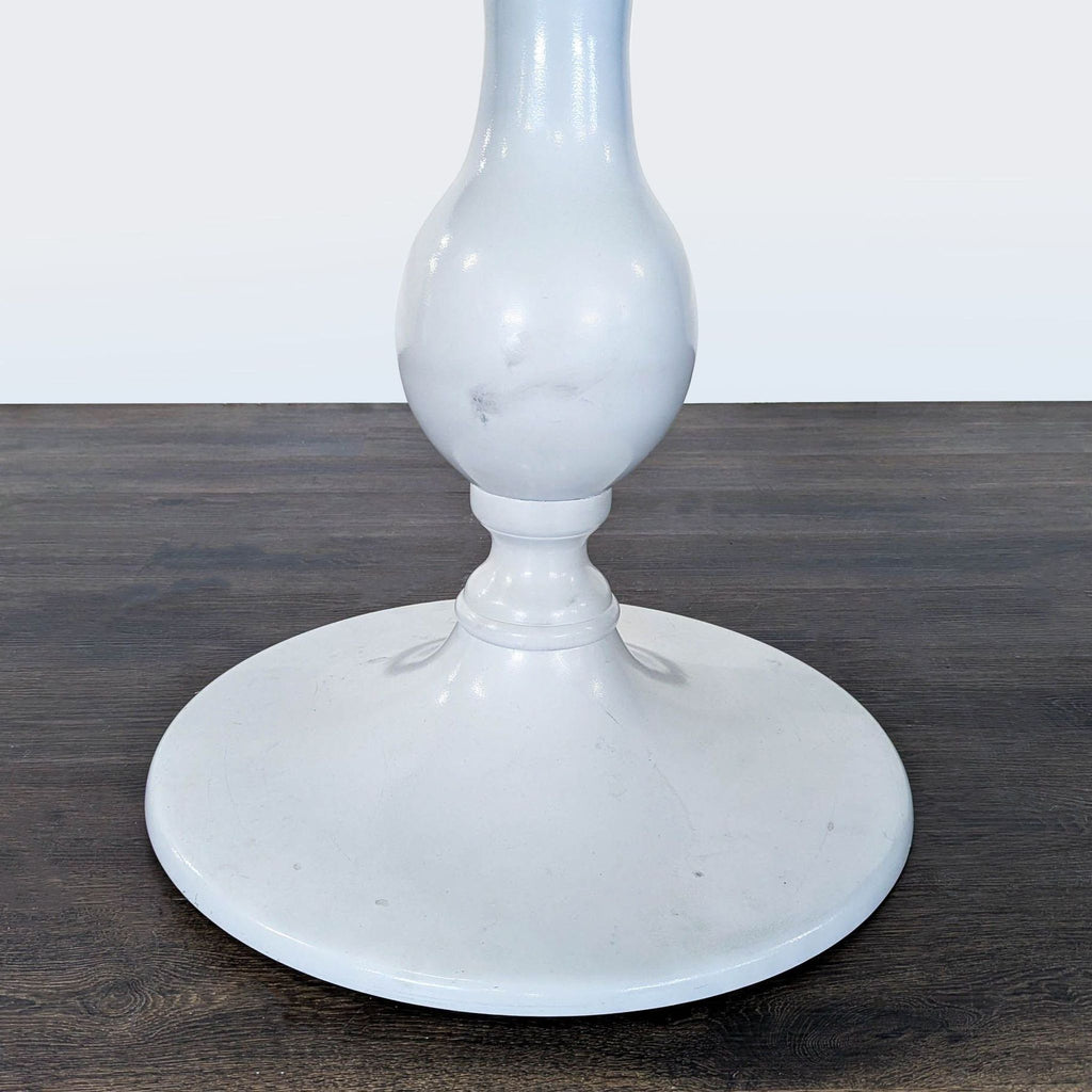 Modern Anthropologie dining table showcasing a metal pedestal base design.