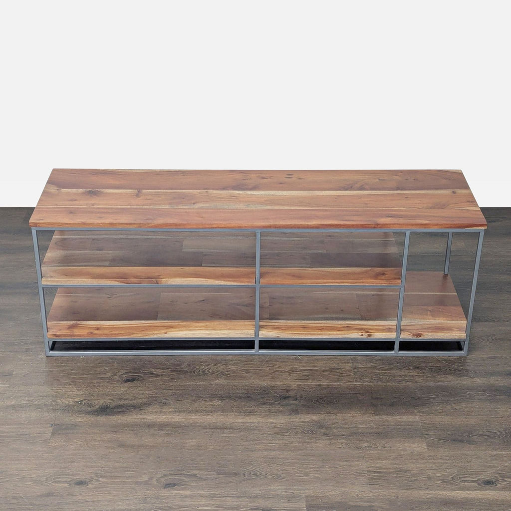 CB2 entertainment center featuring three acacia wood shelves with a sleek metal frame.