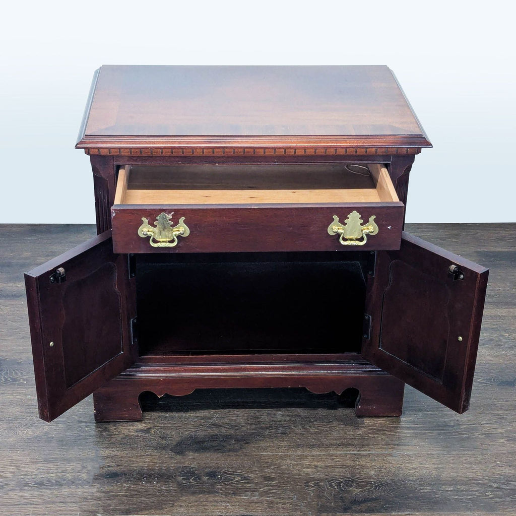 Elegant Thomasville end table featuring dental molding, a single drawer, and recessed cabinet doors in mahogany.
