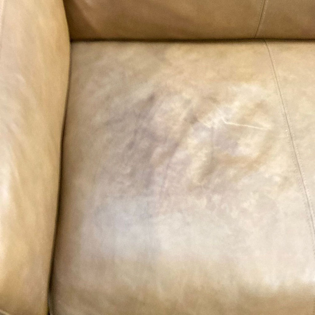 3. Close-up of the tan leather seat cushion on a Copenhagen Furniture 3-seat sofa, showing natural wear.